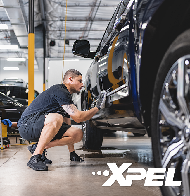 Technician tinting car window garage