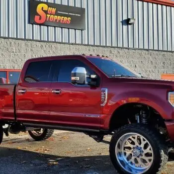 Lifted red truck with window tint