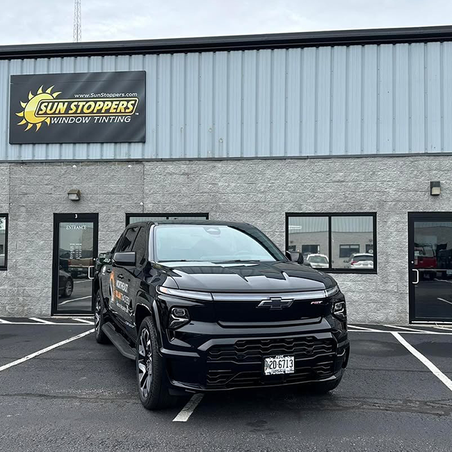 Black truck outside window tinting shop